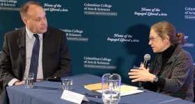 CCAS Dean Paul Wahlbeck (left) at a blue table speaking with Political Science Professor Sarah Binder