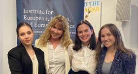 Four women in front of a sign