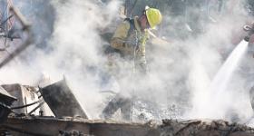 A firefighter moves through wreckage from the 2025 Eaton Fire. (Wikimedia Commons)