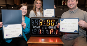 3MT winners (from left) Sarah Kleb, Natalie Boyle and Alex Edwards hold their certificates in front of a clock