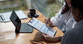 A patient and doctor consult over insurance paperwork.