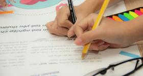 Image of students coloring in a classroom. 