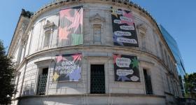 The Flagg Building is adorned with banners promoting NEXT