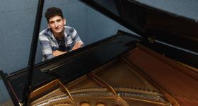 Zach Gindi-Chiafullo sits at the piano keyboard